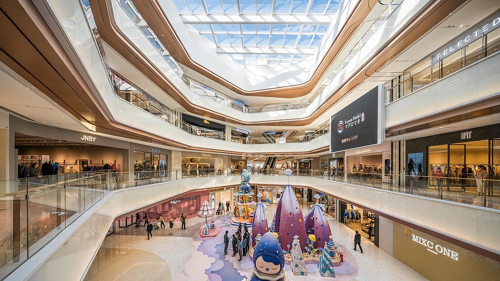 A large building with a large glass ceiling and a large group of people.
